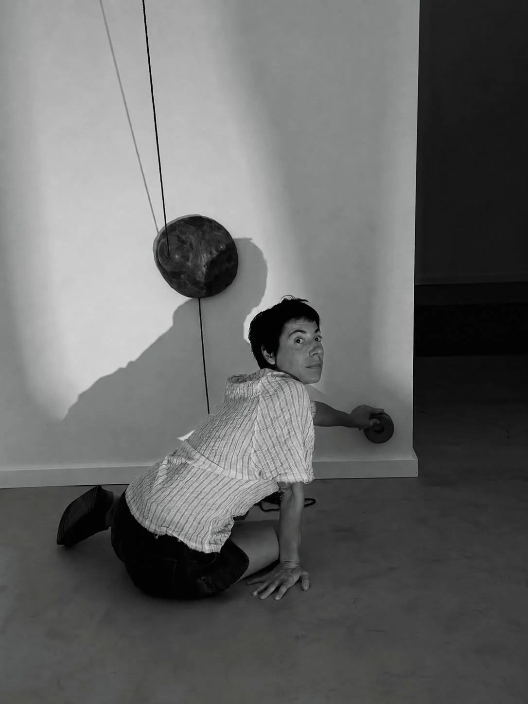 Esmeralda Kosmatopoulos kneeling beside one of her sculptures, black and white portrait